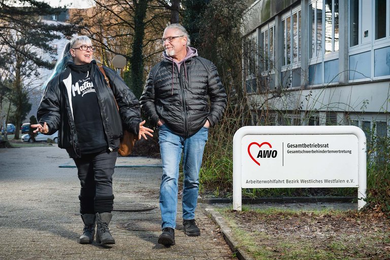 Eine Beschäftigte und ein Beschäftigter der AWO auf der Straße