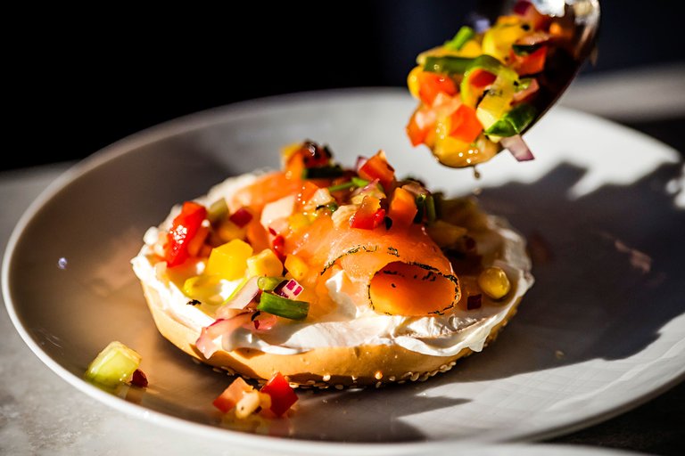 Ein Bagel mit Frischkäse , Gemüse und Lachs